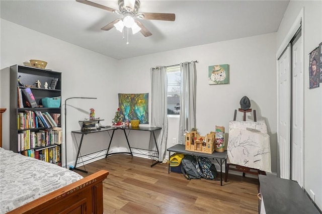 bedroom featuring a closet, light hardwood / wood-style flooring, and ceiling fan