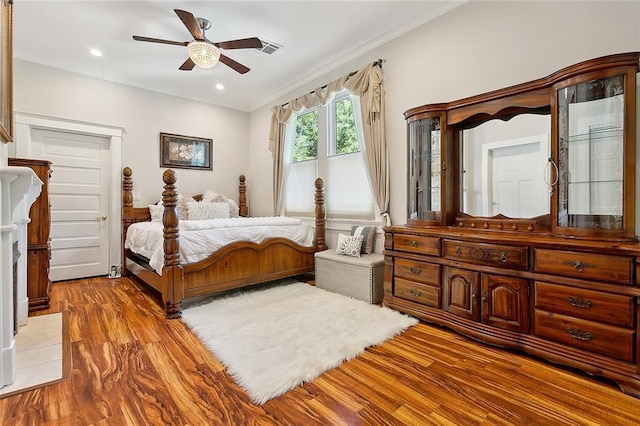 bedroom with hardwood / wood-style floors, ceiling fan, and crown molding