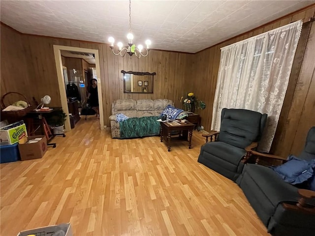 sitting room featuring wood walls, wood-type flooring, and an inviting chandelier