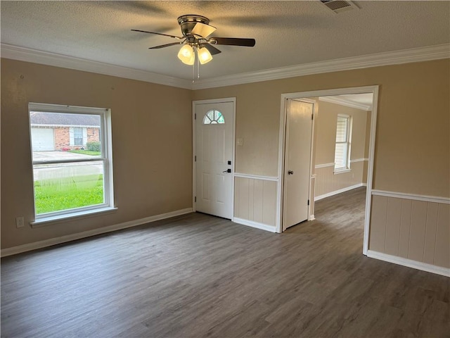 foyer entrance with a textured ceiling, ceiling fan, crown molding, and dark wood-type flooring