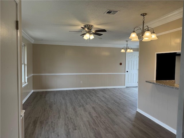 spare room featuring a textured ceiling, ceiling fan with notable chandelier, dark hardwood / wood-style flooring, and crown molding