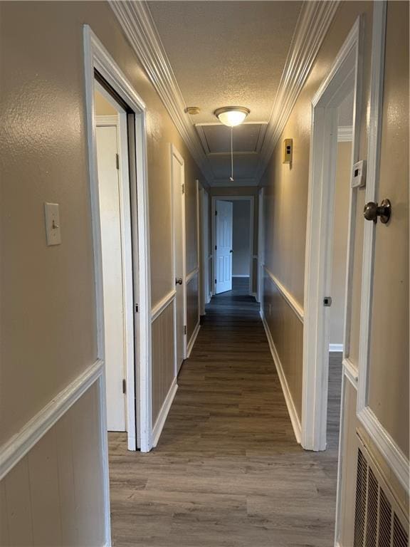 corridor featuring ornamental molding, a textured ceiling, and hardwood / wood-style flooring