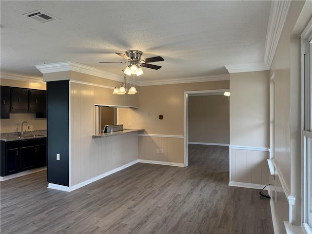 kitchen featuring a textured ceiling, dark hardwood / wood-style floors, kitchen peninsula, and crown molding