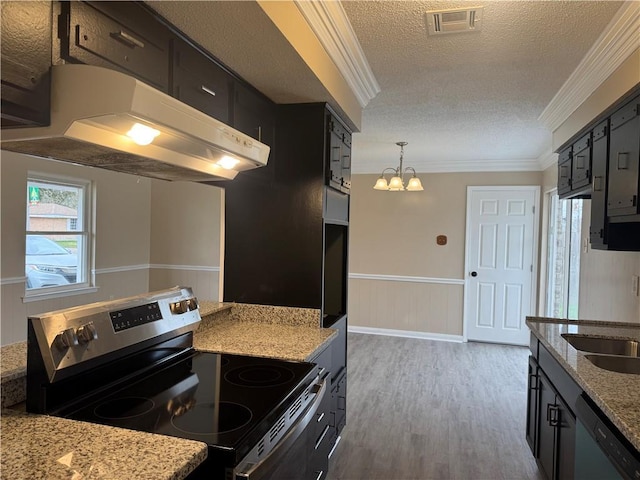 kitchen with hanging light fixtures, dark wood-type flooring, stainless steel appliances, a textured ceiling, and ornamental molding