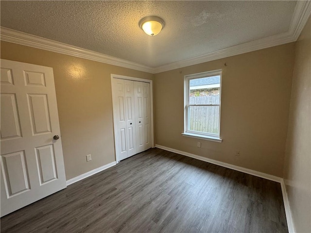 unfurnished bedroom featuring dark hardwood / wood-style floors, crown molding, a textured ceiling, and a closet