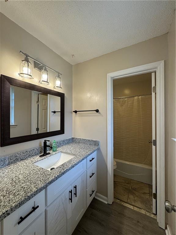 full bathroom featuring vanity, a textured ceiling, hardwood / wood-style flooring, and toilet