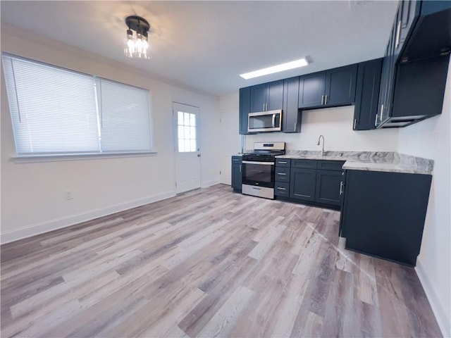 kitchen featuring light stone countertops, stainless steel appliances, light hardwood / wood-style flooring, and sink