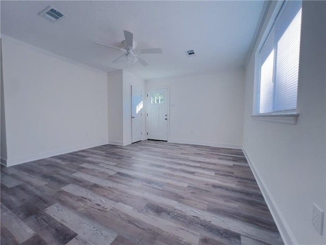 spare room featuring crown molding, plenty of natural light, ceiling fan, and hardwood / wood-style floors