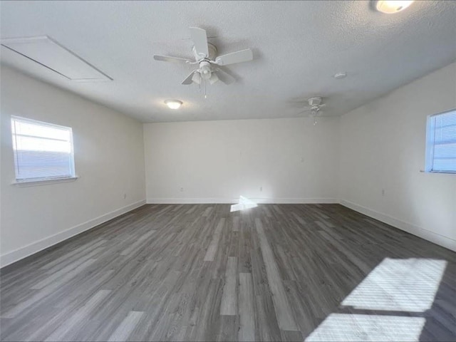 unfurnished room with a textured ceiling, ceiling fan, and dark wood-type flooring