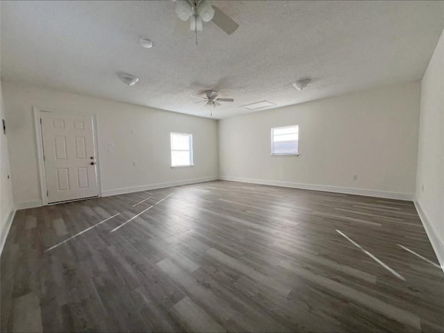 empty room with ceiling fan, dark hardwood / wood-style flooring, and a textured ceiling