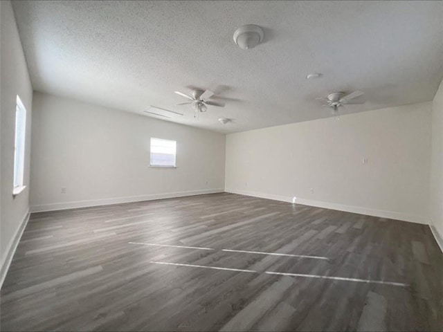 unfurnished room featuring dark hardwood / wood-style floors, ceiling fan, and a textured ceiling