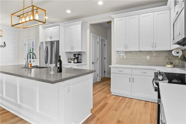 kitchen with sink, white cabinetry, light wood-type flooring, pendant lighting, and stainless steel appliances