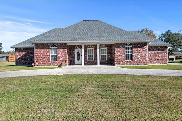 single story home with brick siding, a shingled roof, and a front lawn