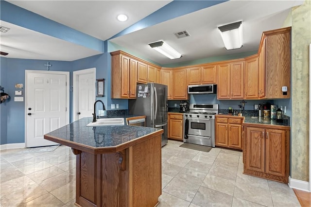 kitchen with a sink, baseboards, a peninsula, appliances with stainless steel finishes, and visible vents