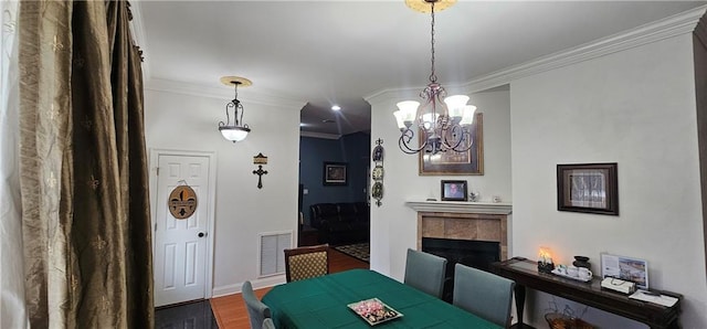 41212 Happywoods Rd, Hammond, LA 70403 - dining room featuring a chandelier, crown molding, wood finished floors, a tile fireplace, and baseboards