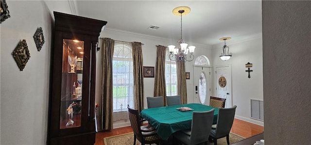 41212 Happywoods Rd, Hammond, LA 70403 - dining room with dark wood-type flooring, ornamental molding, a chandelier, baseboards, and healthy amount of natural light