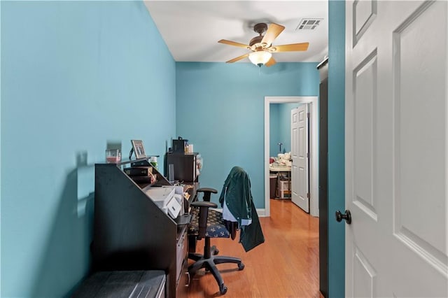 home office with a ceiling fan, visible vents, and light wood-style floors