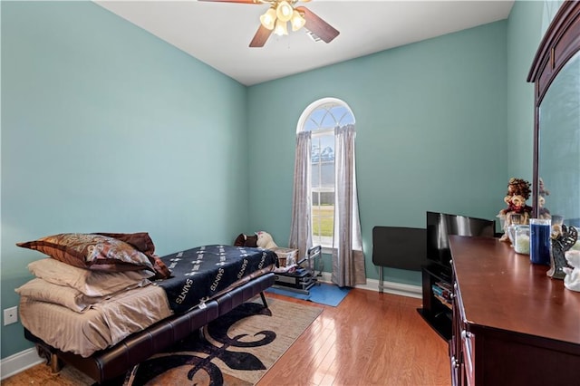 bedroom featuring baseboards, a ceiling fan, and wood finished floors