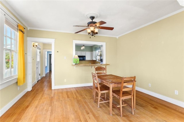 dining area featuring light hardwood / wood-style floors, ceiling fan, and ornamental molding