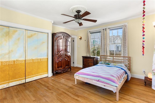 bedroom featuring ceiling fan, wood-type flooring, and ornamental molding