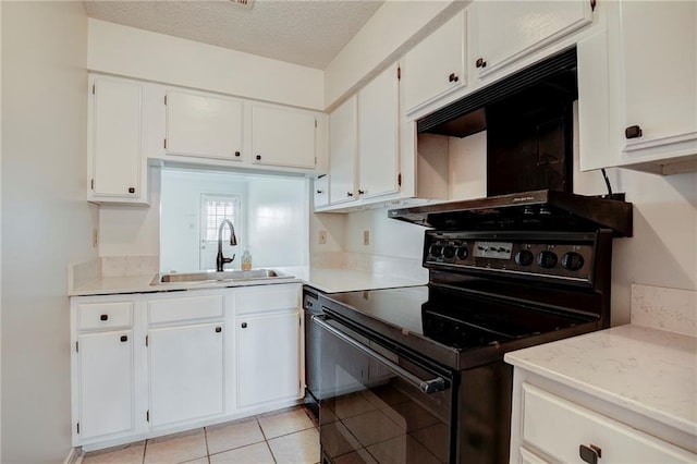 kitchen with black stove, sink, light tile patterned floors, a textured ceiling, and white cabinets