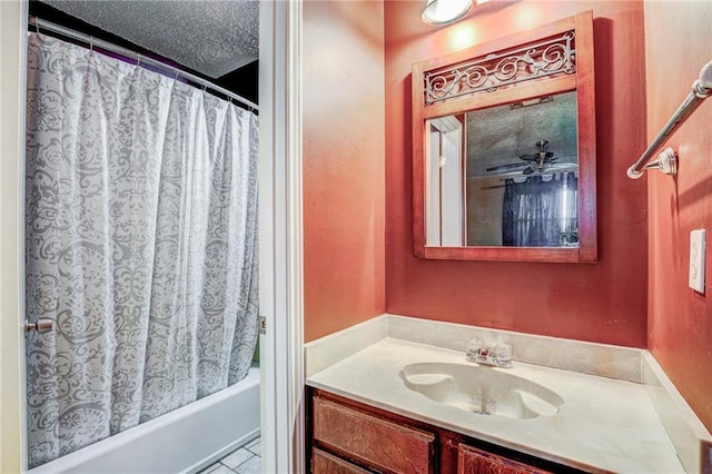 bathroom with vanity, shower / bathtub combination with curtain, and a textured ceiling