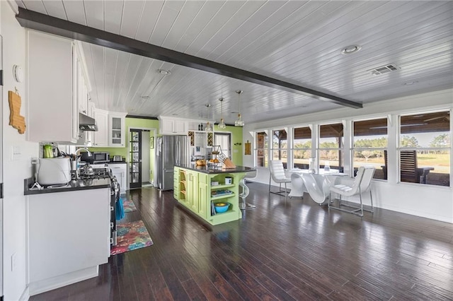 kitchen featuring white cabinetry, a center island, dark wood-type flooring, beamed ceiling, and appliances with stainless steel finishes