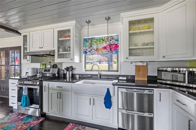 kitchen with appliances with stainless steel finishes, dark hardwood / wood-style flooring, sink, pendant lighting, and white cabinetry