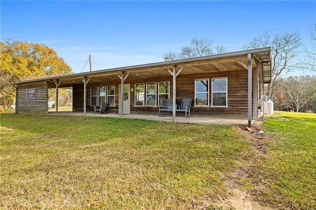 back of house with a lawn and a patio area