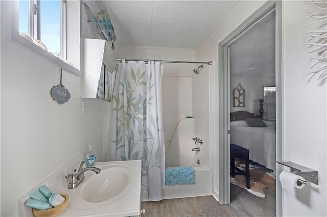 bathroom featuring hardwood / wood-style floors, vanity, shower / bath combo with shower curtain, and ornamental molding