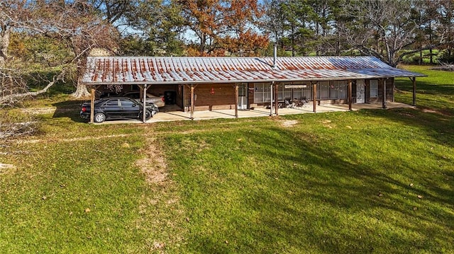 exterior space with a carport and a lawn