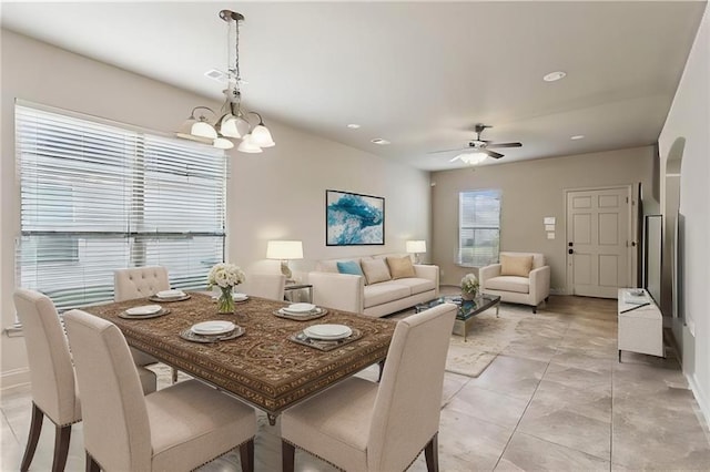 dining room with ceiling fan with notable chandelier and light tile patterned flooring