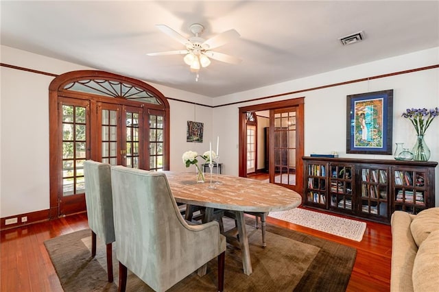 dining space featuring french doors, ceiling fan, and dark wood-type flooring