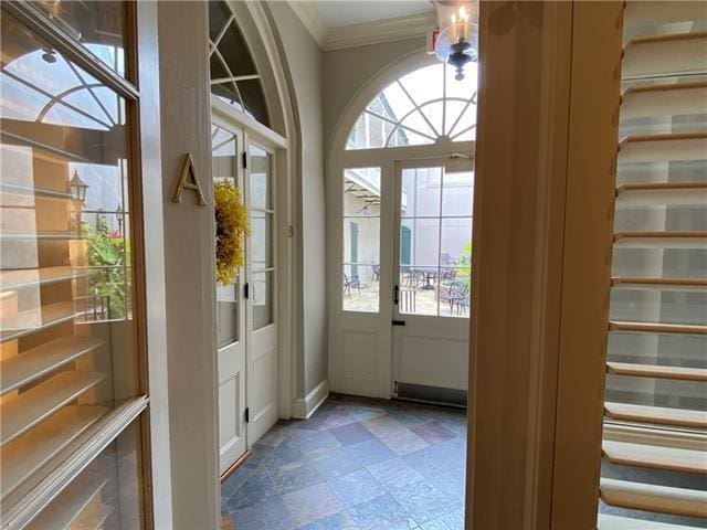 doorway featuring plenty of natural light and ornamental molding