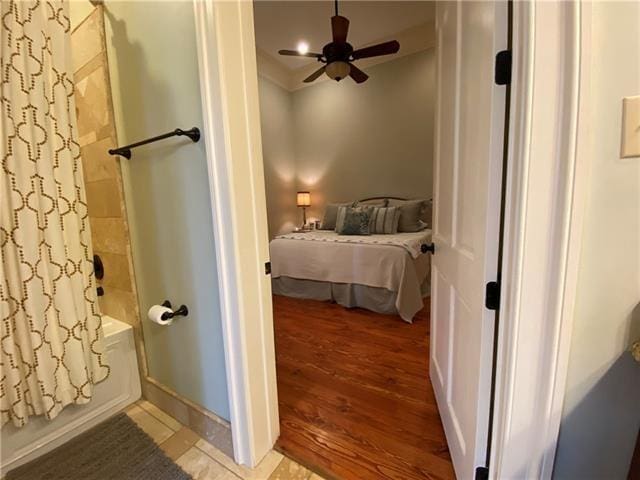 bathroom featuring hardwood / wood-style floors, ceiling fan, and shower / tub combo with curtain