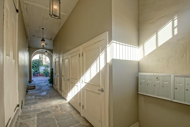 hall with a mail area and a high ceiling