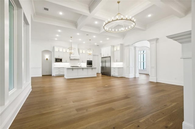 unfurnished living room with beam ceiling, ornamental molding, dark wood-type flooring, and coffered ceiling