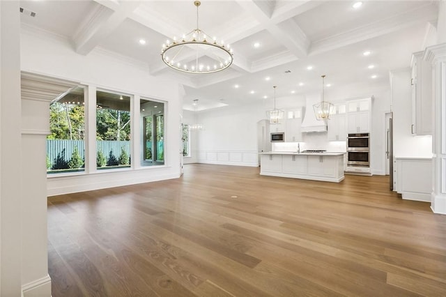 unfurnished living room with beam ceiling, hardwood / wood-style flooring, and coffered ceiling