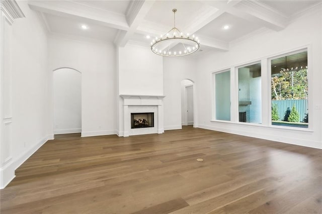 unfurnished living room featuring beamed ceiling, dark hardwood / wood-style floors, ornamental molding, and coffered ceiling