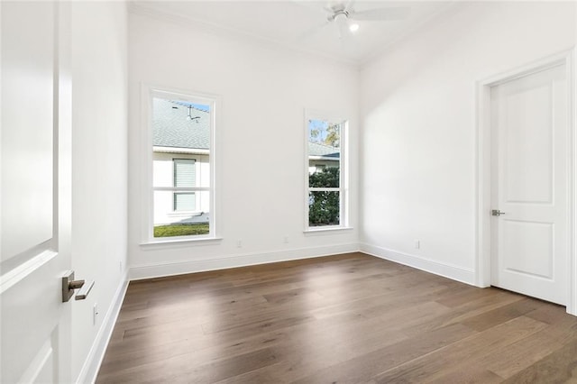 empty room with ceiling fan, dark hardwood / wood-style flooring, and ornamental molding