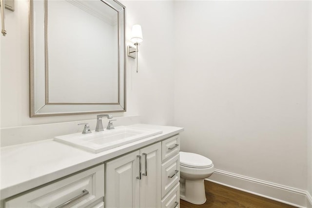 bathroom with hardwood / wood-style floors, vanity, and toilet