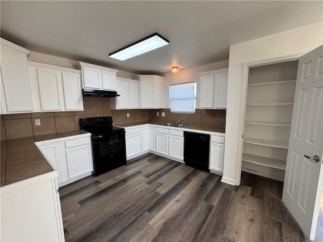 kitchen with black appliances, white cabinetry, backsplash, and dark wood-type flooring