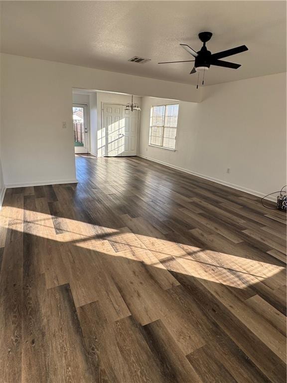 empty room with a textured ceiling, ceiling fan, and dark wood-type flooring