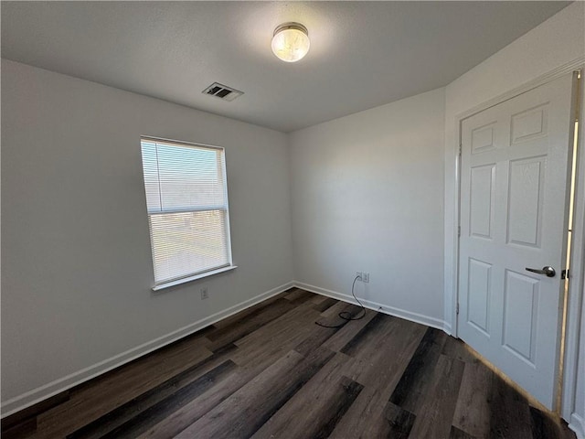 empty room with dark hardwood / wood-style flooring