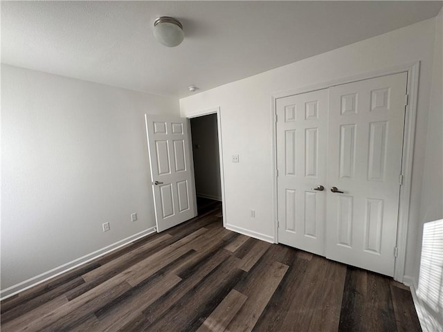 unfurnished bedroom featuring a closet and dark hardwood / wood-style floors