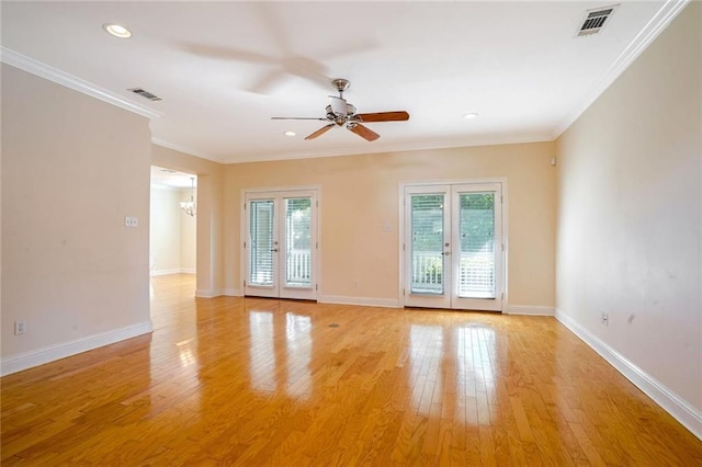 empty room with ceiling fan, crown molding, light hardwood / wood-style flooring, and french doors