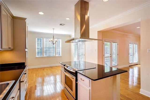 5913 Catina St, New Orleans, LA 70124 - kitchen with island exhaust hood, stainless steel range with electric stovetop, dark countertops, ornamental molding, and a chandelier