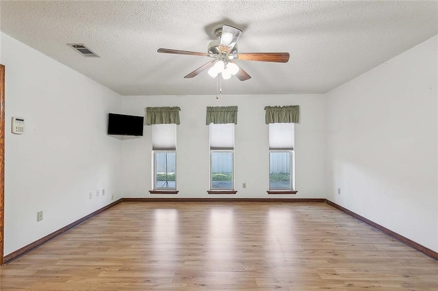 spare room featuring ceiling fan, a textured ceiling, and light hardwood / wood-style flooring