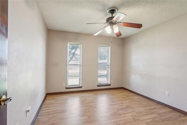 spare room with ceiling fan, a textured ceiling, and light hardwood / wood-style flooring