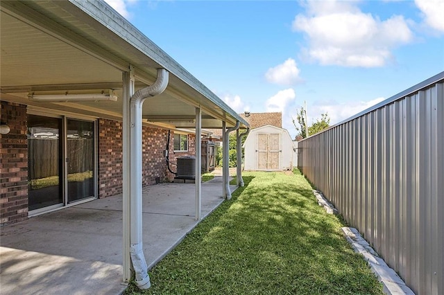 view of yard featuring a patio, central AC unit, and a storage shed